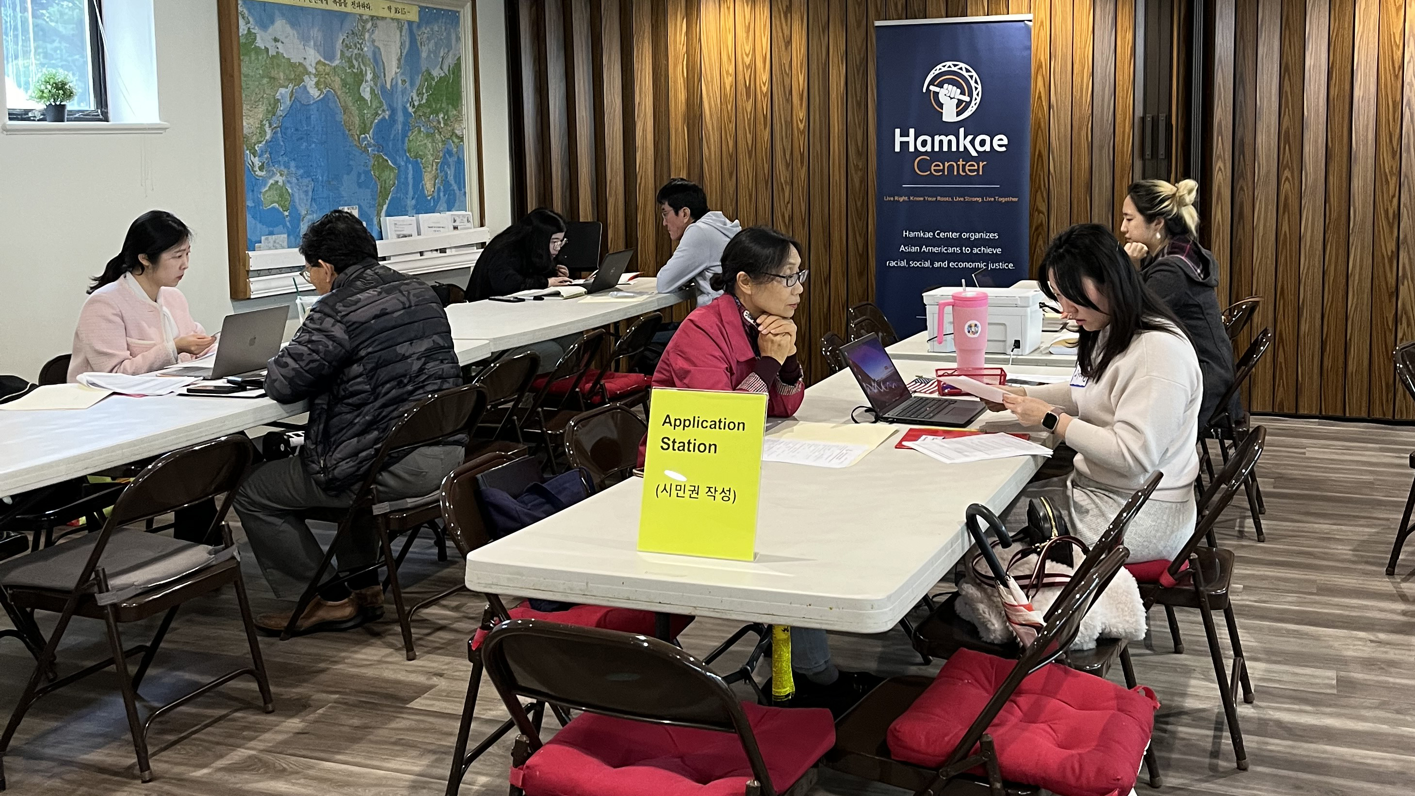 Hamkae Center staff, and volunteer immigration lawyers reviewing community members' citizenship applications at Hamkae Center's Citizenship Clinic inside a room at Saehan Presbyterian Church.